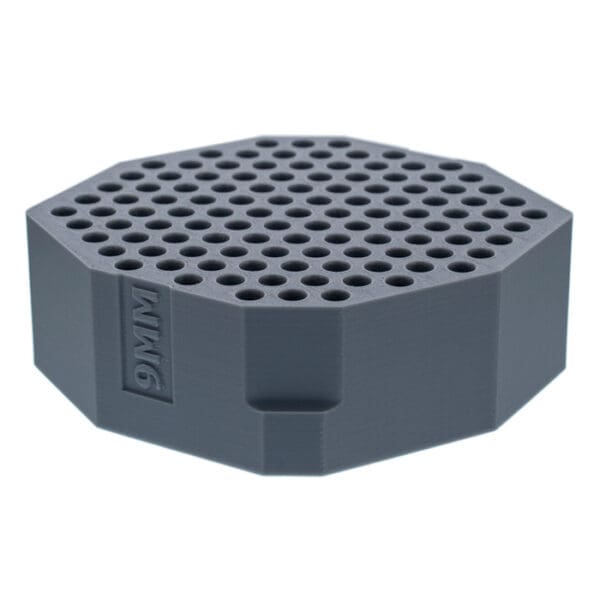 Hexagonal grey object with holes.