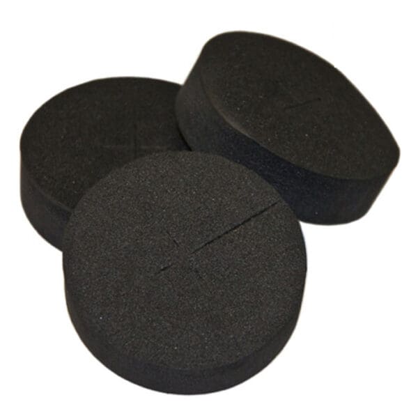 Three round black foam pads stacked together.