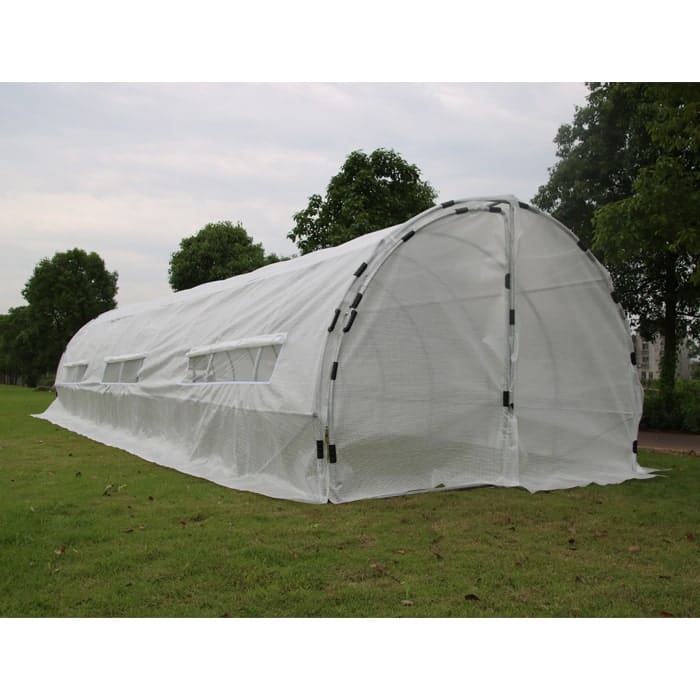 Greenhouse with white cover on grass.