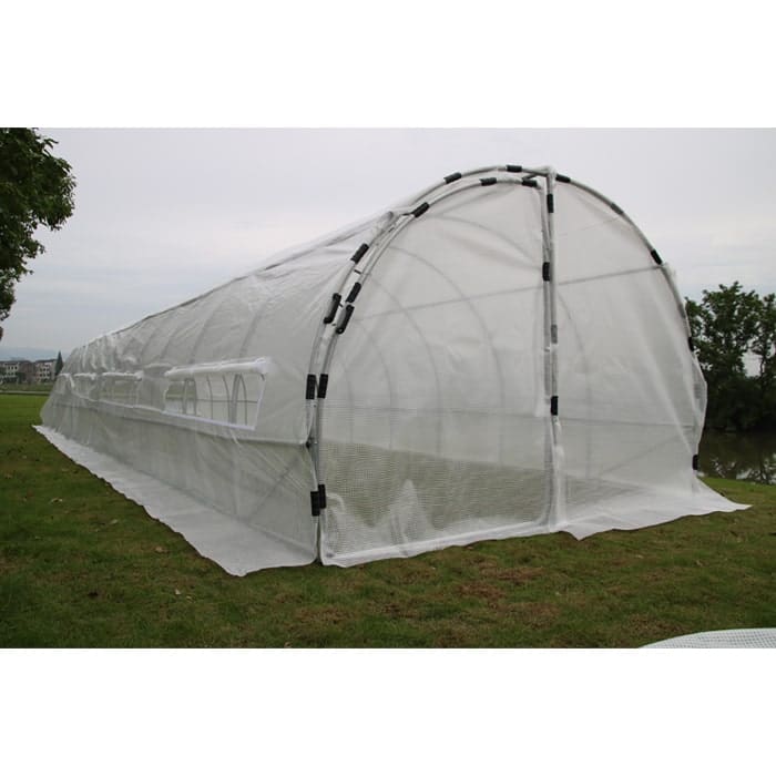 Greenhouse structure on grassy field.