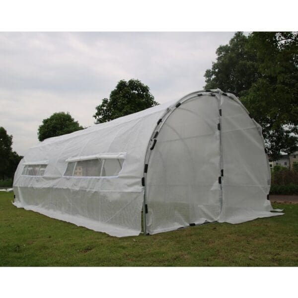 White greenhouse structure in a grassy area.