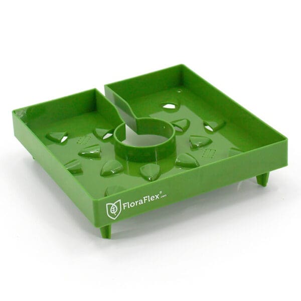 Green plant watering tray with drainage holes.