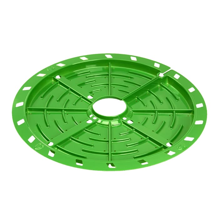 Green circular grid with cutouts and center hole.